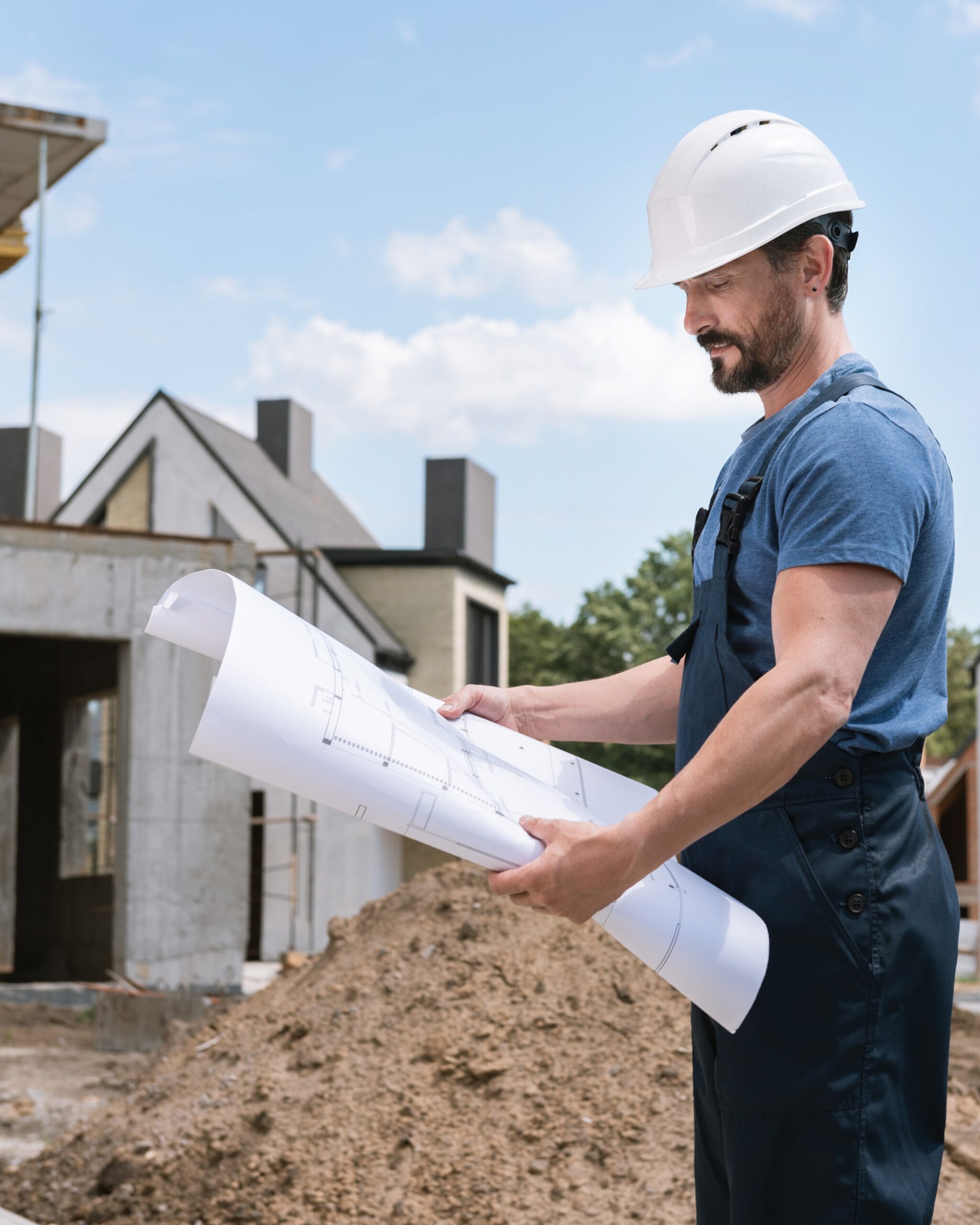 smart professional engineer looking blueprint while being workmm scaled